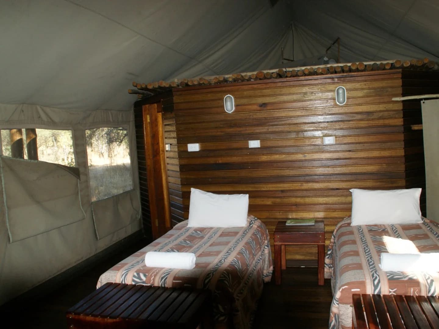 Twin beds inside a canvas and timber tent, Limpopo Forest Tented Camp