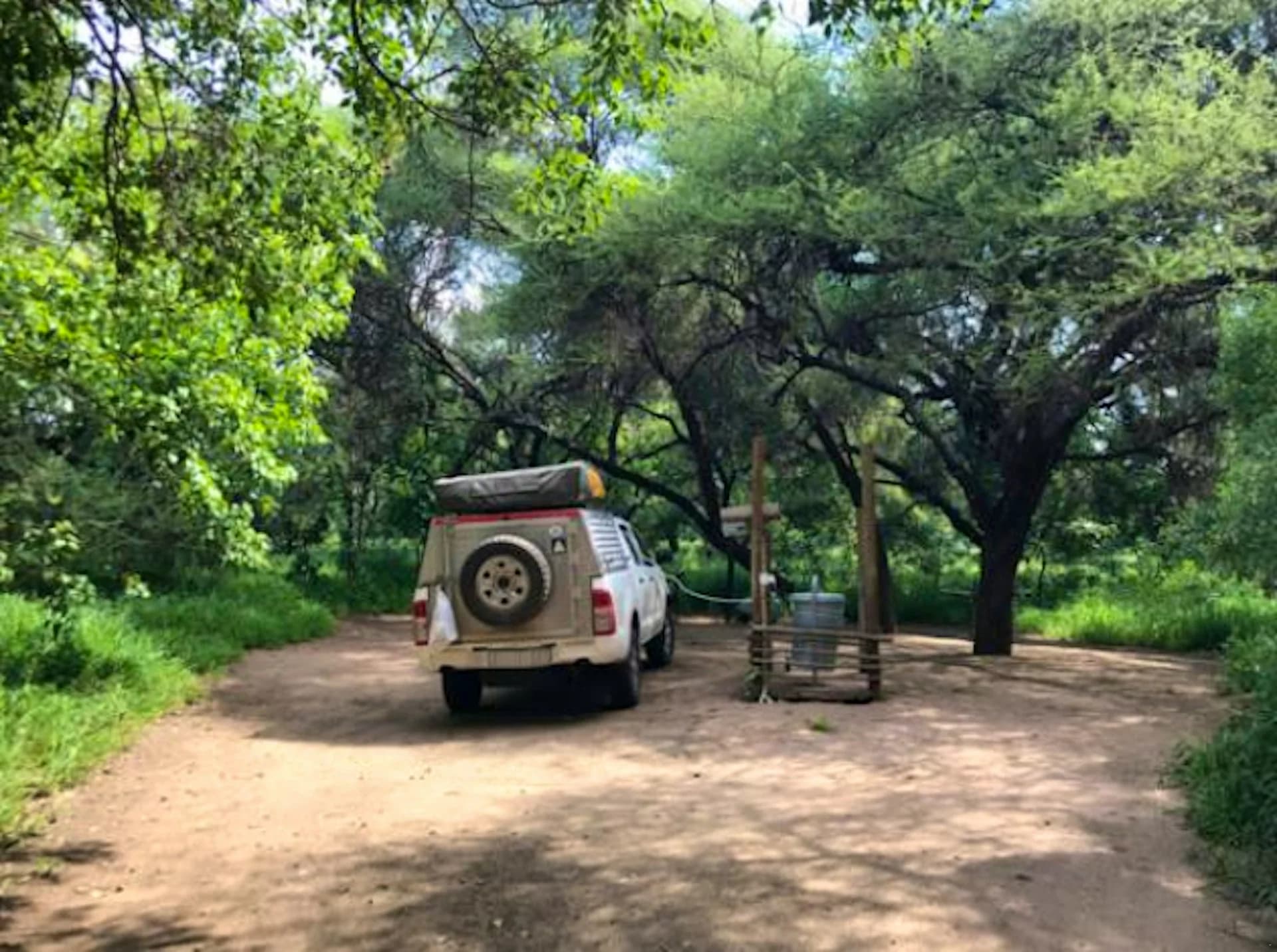 Four-wheel-drive vehicle parked beneath trees at a campsite, Mazhou Camping Site