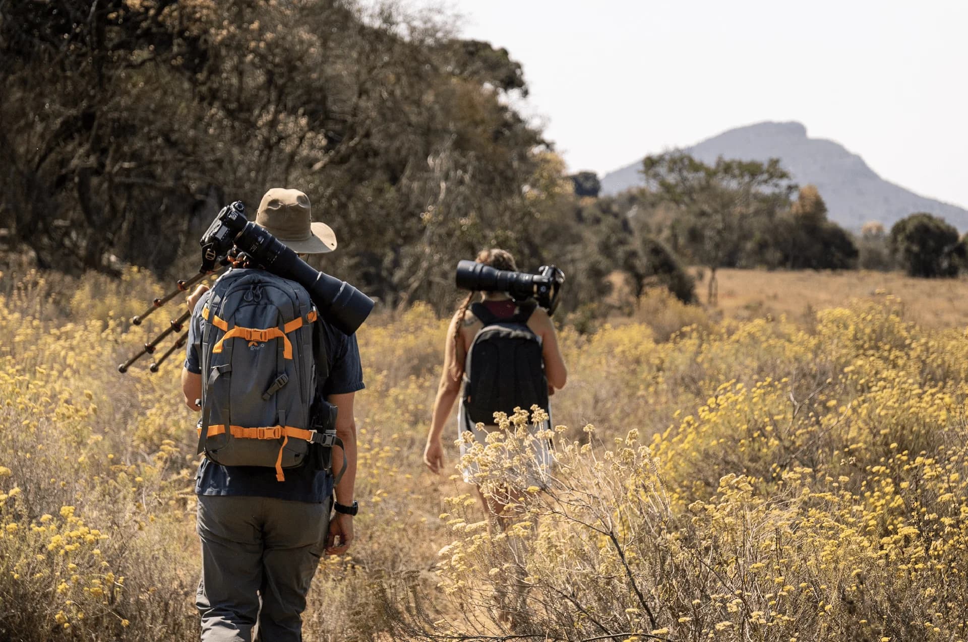 Two walkers carrying backpacks through bushveld, Leshiba hiking trails