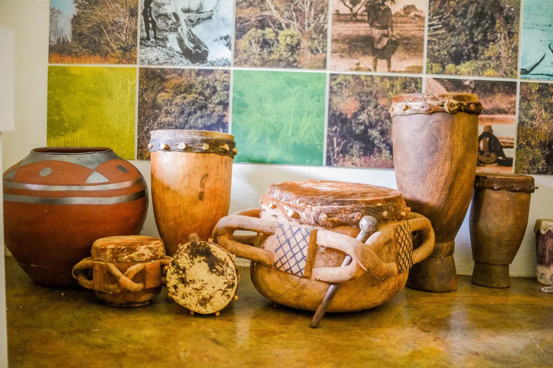 Painted clay pots and carved wooden drums in the lodge's Venda culture gallery, Madi a Thavha cultural tours