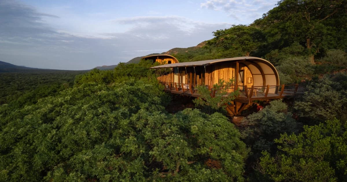 Curved lodge suite above a wooded mountain slope, Few & Far Luvhondo