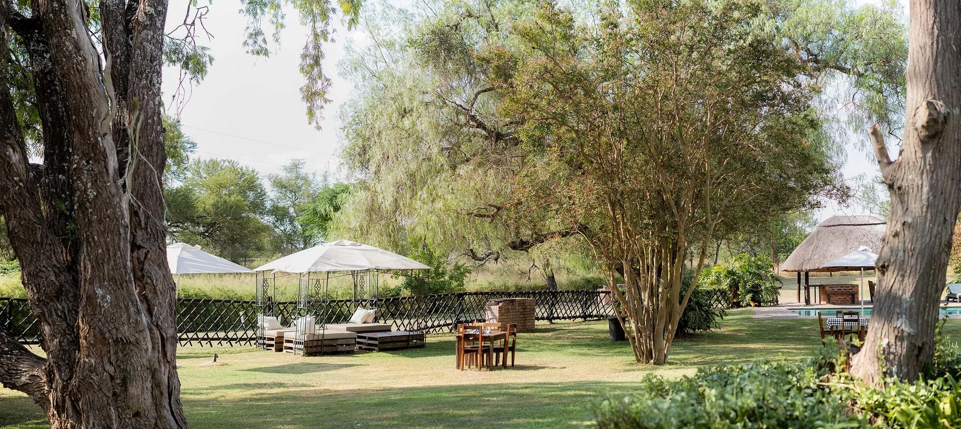 Hotel gardens and buildings beneath trees, Lalapanzi Hotel and camping