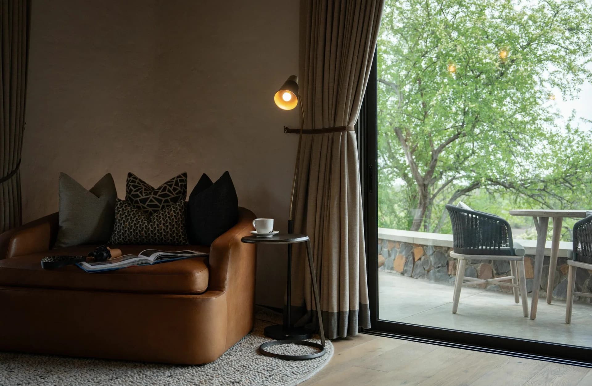 Armchair and glass doors opening onto an outdoor deck, Euphorbia Mashatu