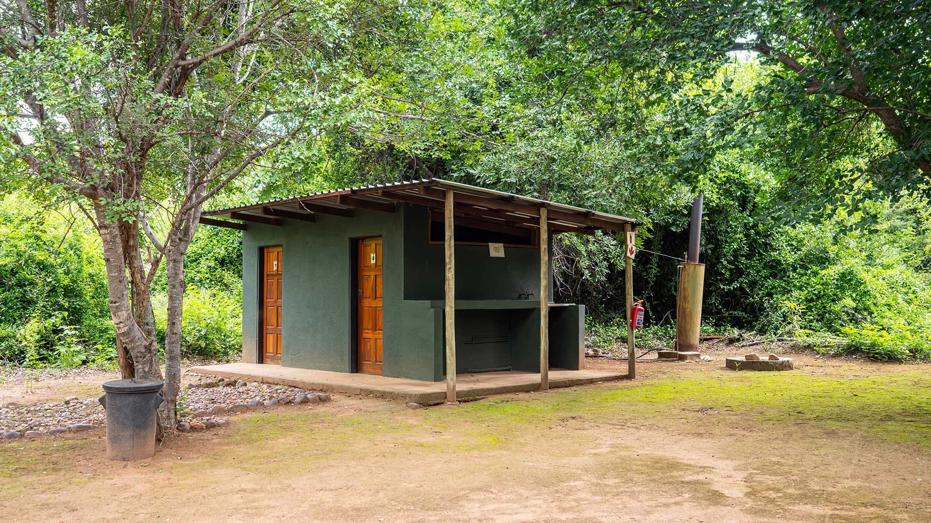 Small timber camp kitchen and wash-up building among trees, Pafuri Rivercamp